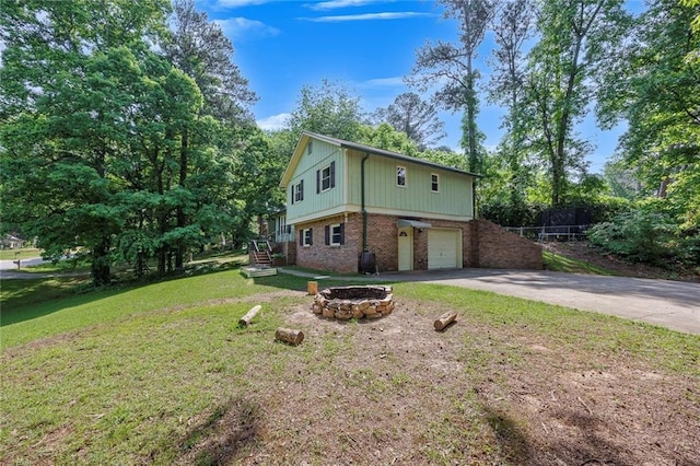 view of front of house featuring a front yard, brick siding, an attached garage, and aphalt driveway
