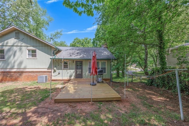 rear view of property featuring central air condition unit, a chimney, fence, and a wooden deck