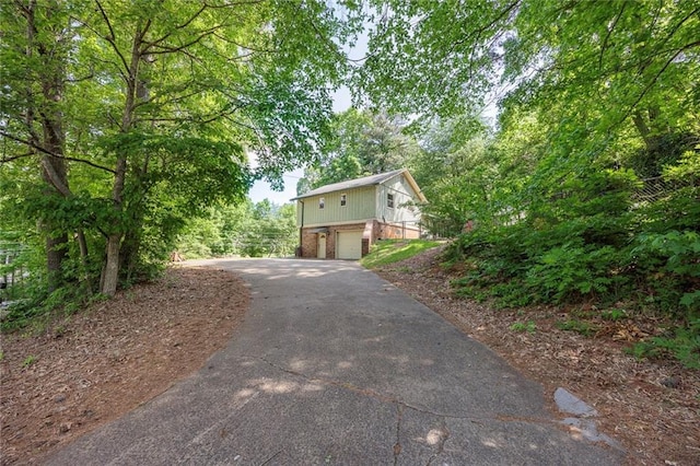 exterior space featuring brick siding, aphalt driveway, and an attached garage