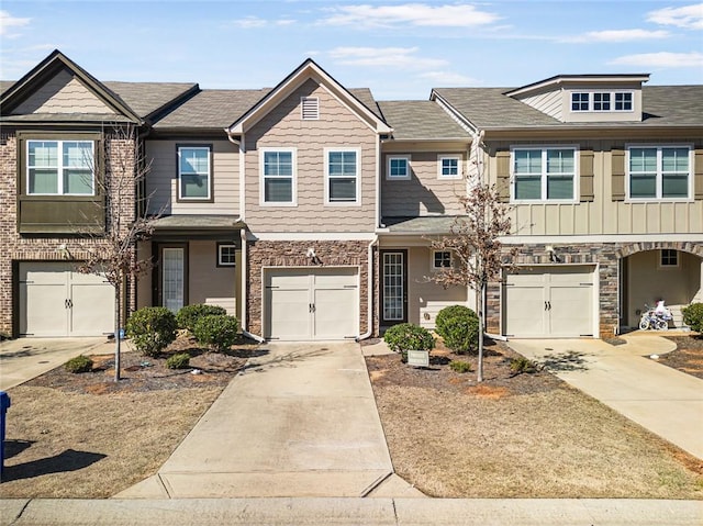 view of property with an attached garage, stone siding, and concrete driveway