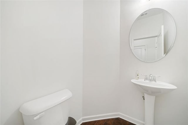 bathroom featuring toilet, baseboards, and wood finished floors