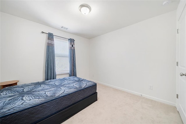 bedroom featuring baseboards, visible vents, and light colored carpet