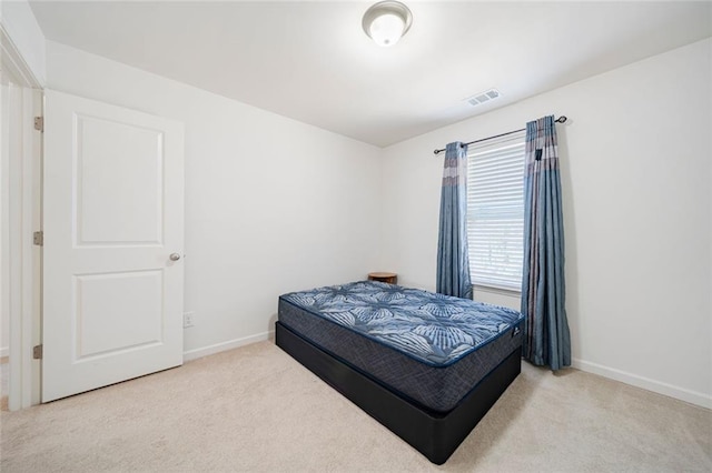 carpeted bedroom with visible vents and baseboards