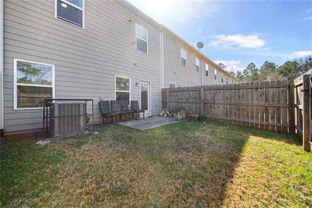 rear view of property with a fenced backyard, a lawn, and a patio