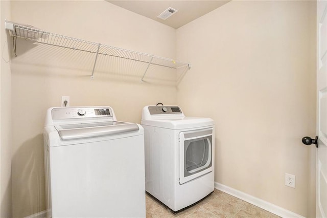 381 Homestead Cir, Forsyth, GA 31029 - laundry area with washing machine and dryer and light tile patterned floors