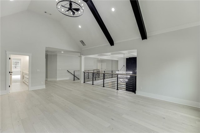 living room with a notable chandelier, beam ceiling, and light hardwood / wood-style floors