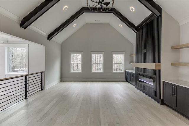 unfurnished living room featuring beamed ceiling, plenty of natural light, high vaulted ceiling, and light wood-type flooring