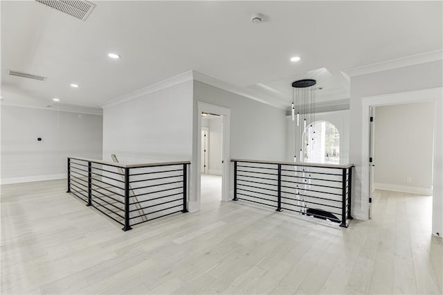 spare room featuring crown molding and light hardwood / wood-style floors