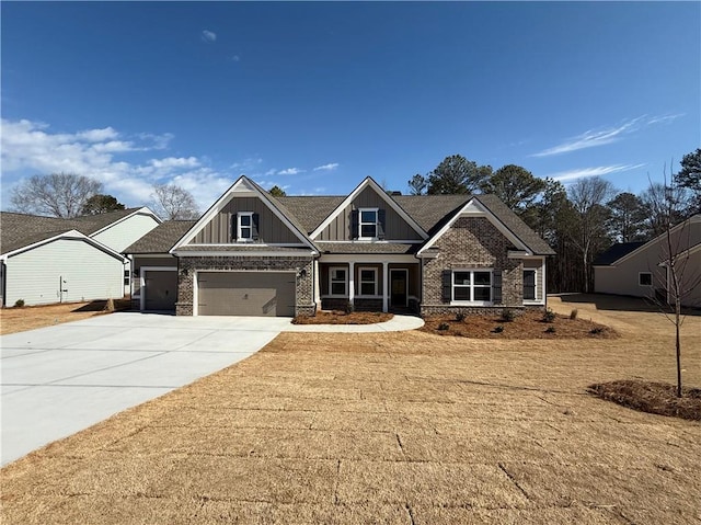 craftsman inspired home with a garage, brick siding, board and batten siding, and concrete driveway