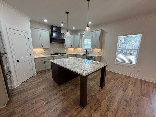 kitchen with a sink, gas stovetop, custom range hood, backsplash, and crown molding