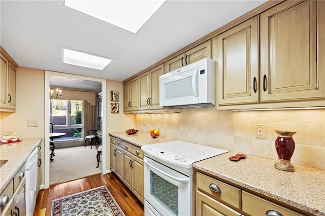 kitchen with tasteful backsplash, light stone countertops, white appliances, dark hardwood / wood-style floors, and a chandelier