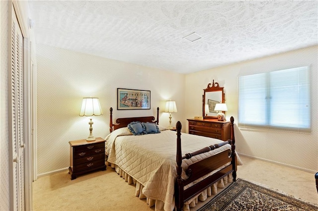 bedroom featuring a textured ceiling and light colored carpet