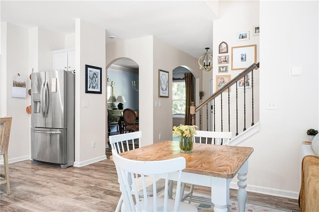 1417 Woodrow Kay Rd, Rockmart, GA 30153 - dining room featuring arched walkways, light wood finished floors, baseboards, and stairs