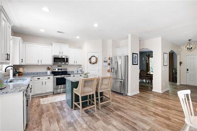 1417 Woodrow Kay Rd, Rockmart, GA 30153 - kitchen featuring appliances with stainless steel finishes, a sink, arched walkways, a center island, and white cabinets