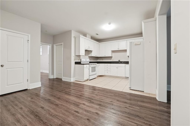 kitchen featuring white appliances, light hardwood / wood-style floors, white cabinetry, and sink