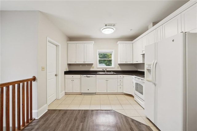 kitchen with white cabinets, white appliances, sink, and light hardwood / wood-style flooring