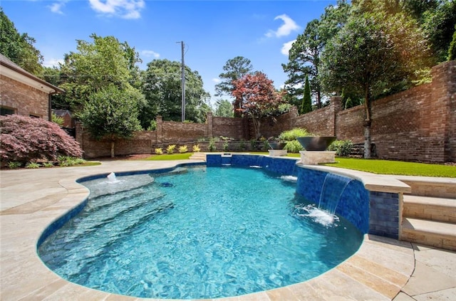 view of swimming pool with pool water feature and a patio