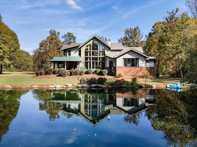 back of house featuring a yard and a water view