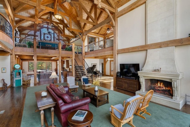 living room featuring dark wood-type flooring, beam ceiling, high vaulted ceiling, and a fireplace