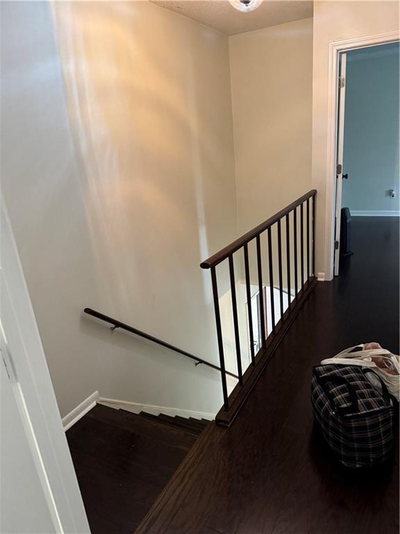 stairway featuring wood finished floors and baseboards