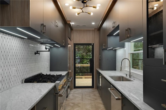 kitchen with light stone counters, stainless steel appliances, a sink, visible vents, and backsplash