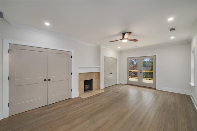 unfurnished living room with french doors, visible vents, light wood-style floors, ornamental molding, and baseboards