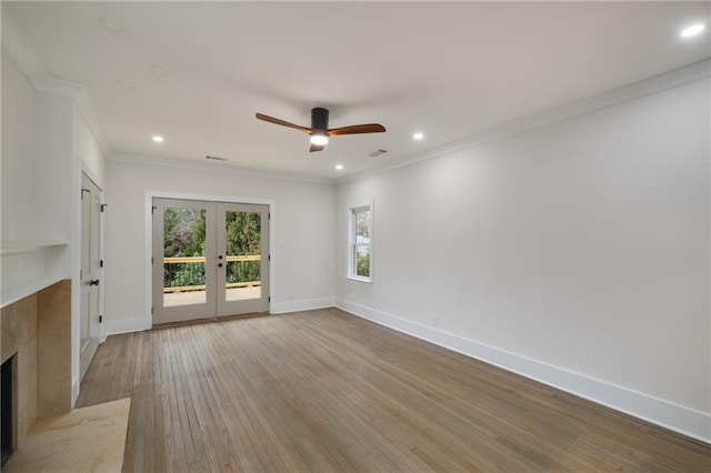 unfurnished living room with a premium fireplace, baseboards, french doors, light wood finished floors, and crown molding