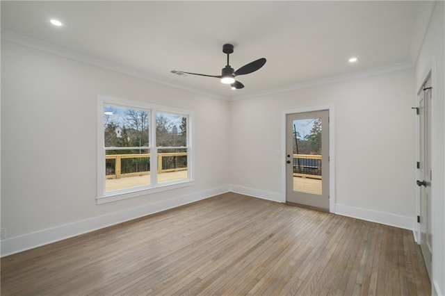 spare room featuring crown molding, visible vents, a ceiling fan, wood finished floors, and baseboards