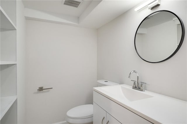 bathroom featuring toilet, vanity, visible vents, and baseboards