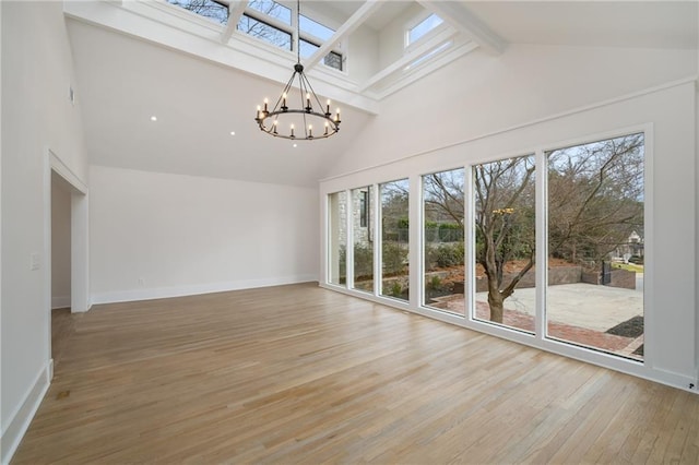 interior space with a chandelier, a healthy amount of sunlight, and high vaulted ceiling