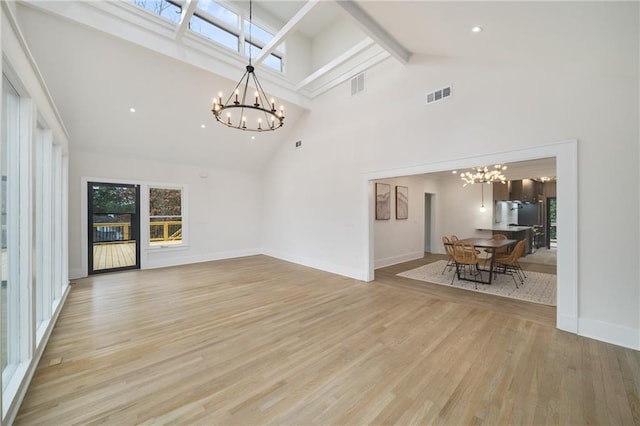 unfurnished living room with light wood-style floors, visible vents, and an inviting chandelier