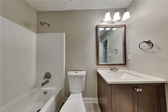 full bathroom with a textured ceiling, vanity,  shower combination, and toilet