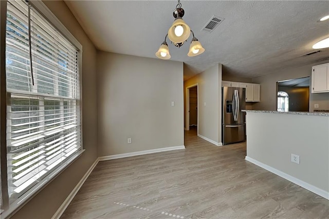 interior space with light hardwood / wood-style floors and an inviting chandelier