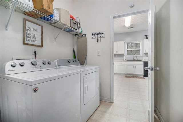 washroom with sink, washer and clothes dryer, and a textured ceiling