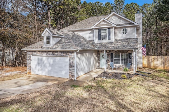 view of property featuring a garage and a front lawn