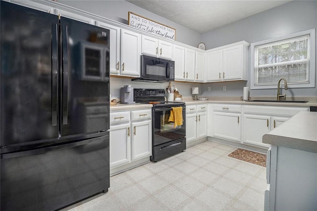 kitchen featuring white cabinetry, sink, a textured ceiling, and black appliances