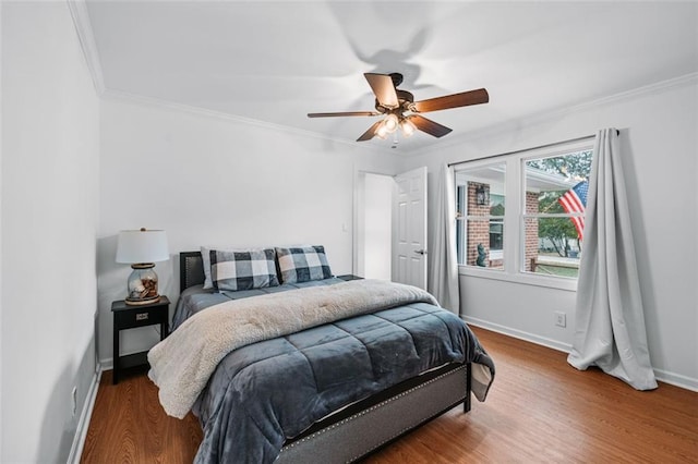 bedroom featuring hardwood / wood-style flooring, ceiling fan, and ornamental molding