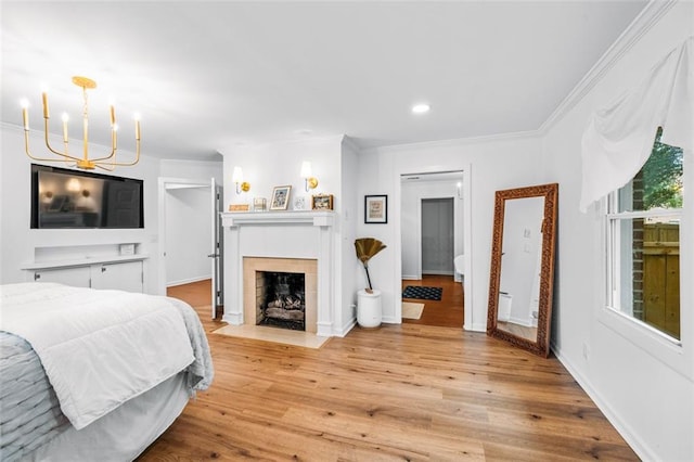 bedroom featuring a fireplace, multiple windows, light wood-type flooring, and ornamental molding