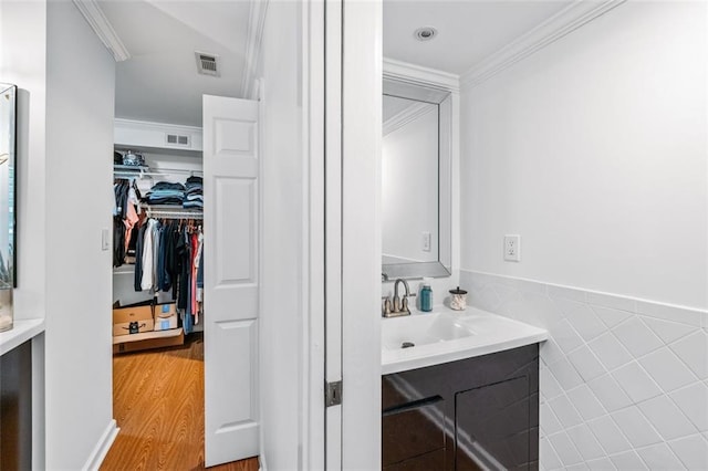 bathroom with vanity, hardwood / wood-style floors, and crown molding