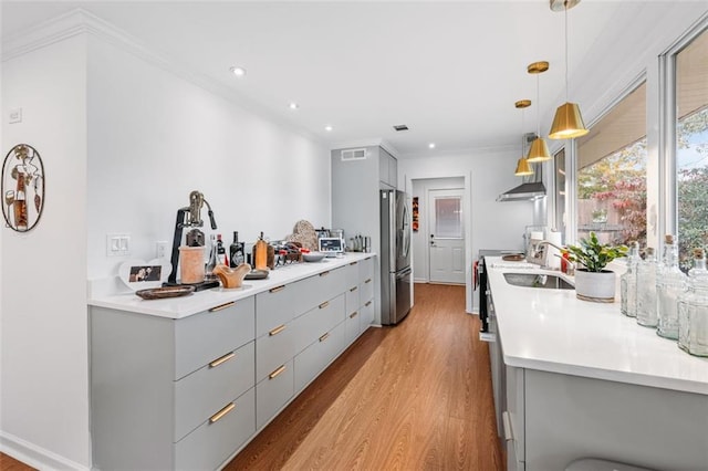 kitchen featuring decorative light fixtures, light hardwood / wood-style flooring, gray cabinets, stainless steel fridge, and electric range