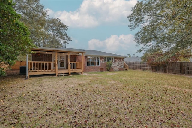 rear view of house with central AC, a yard, and a wooden deck