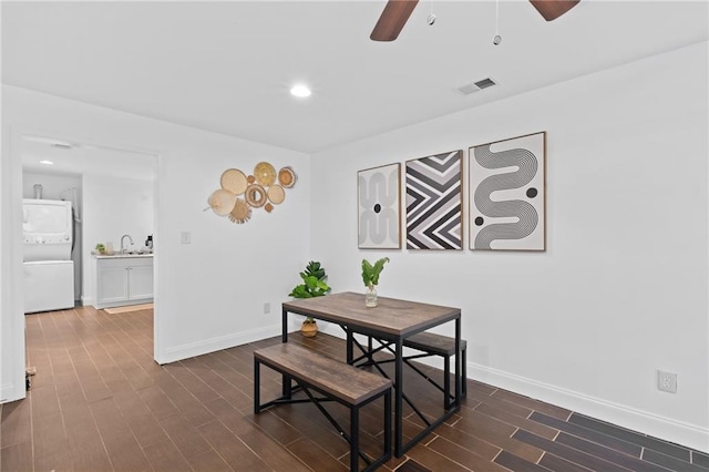 dining area with stacked washer / dryer, a ceiling fan, dark wood finished floors, baseboards, and recessed lighting