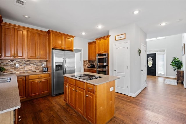 kitchen with stainless steel appliances, dark wood-style floors, backsplash, a center island, and recessed lighting