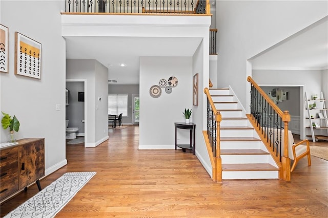 foyer entrance with stairway, wood finished floors, baseboards, and recessed lighting