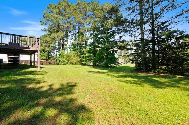 view of grassy yard featuring a deck