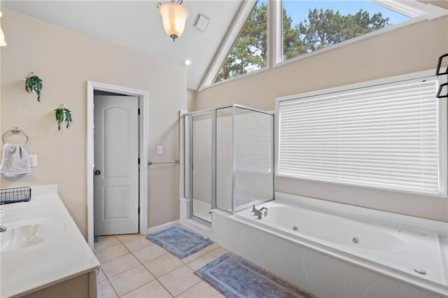 bathroom with a stall shower, a whirlpool tub, vanity, tile patterned flooring, and vaulted ceiling
