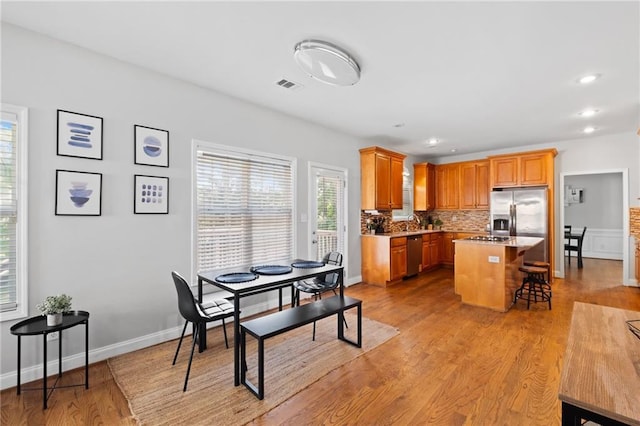 dining room with light wood-style flooring, recessed lighting, and baseboards