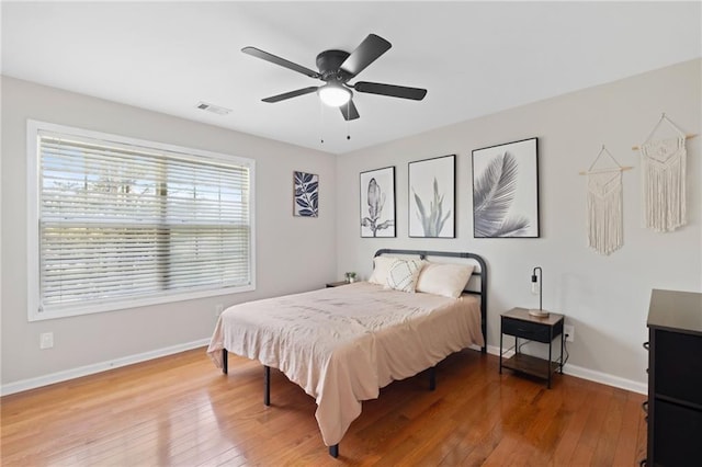 bedroom featuring light wood-style flooring, baseboards, and a ceiling fan