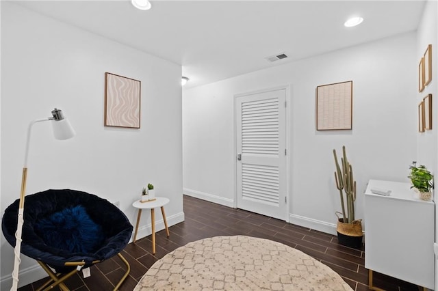 sitting room featuring wood tiled floors, baseboards, and recessed lighting