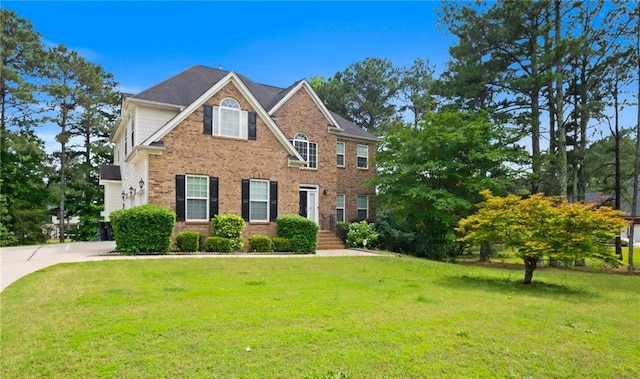 view of front of home with brick siding and a front lawn